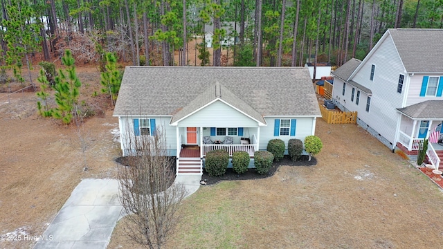 view of front of house featuring covered porch and a shingled roof