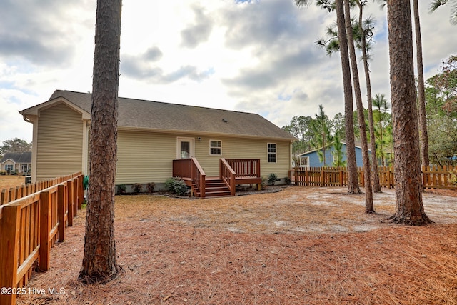 back of house featuring fence private yard and a wooden deck