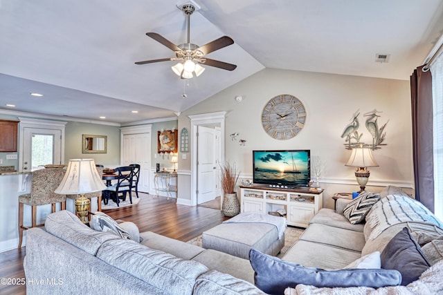 living room with dark wood-type flooring, visible vents, vaulted ceiling, and ceiling fan