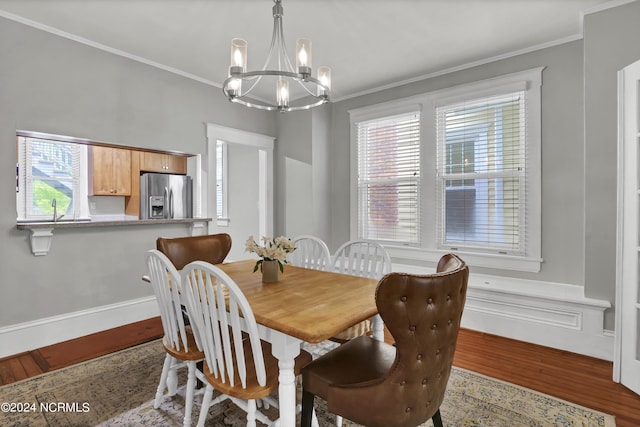 dining room with crown molding, an inviting chandelier, and light hardwood / wood-style floors