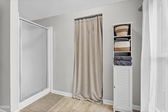 bathroom featuring hardwood / wood-style flooring and walk in shower