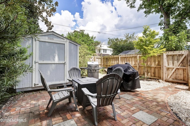 view of patio featuring a grill and a storage unit