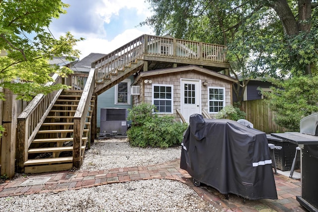 back of property with an outdoor structure and a patio