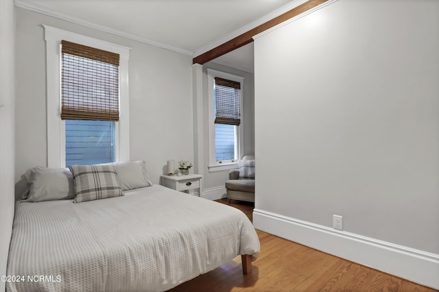 bedroom with crown molding and hardwood / wood-style flooring