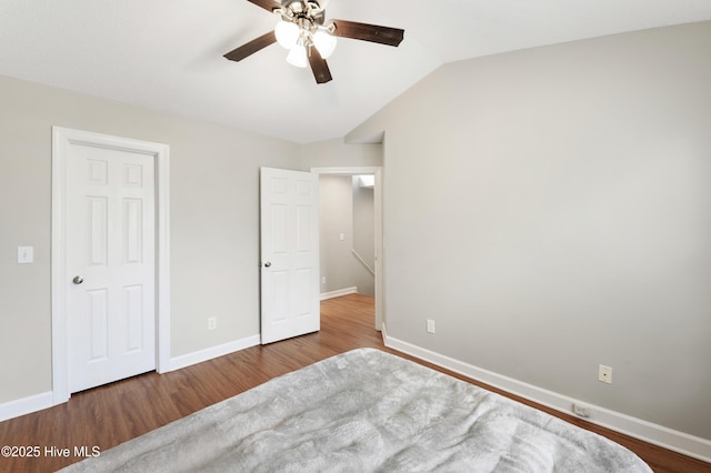 unfurnished bedroom with hardwood / wood-style flooring, vaulted ceiling, and ceiling fan