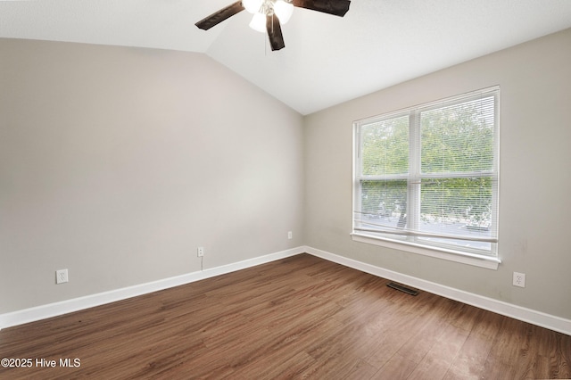 empty room with dark wood-type flooring, ceiling fan, and vaulted ceiling