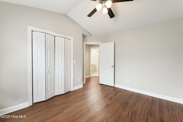 unfurnished bedroom with dark wood-type flooring, ceiling fan, lofted ceiling, and a closet