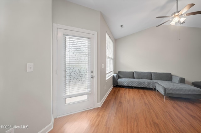 living room featuring lofted ceiling, hardwood / wood-style floors, and ceiling fan