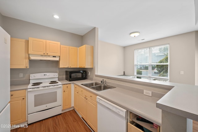 kitchen featuring sink, white appliances, kitchen peninsula, and light wood-type flooring