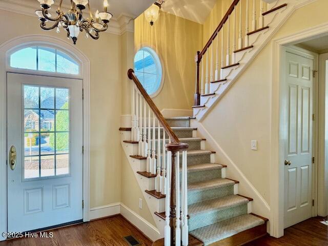 entryway featuring ornamental molding, dark hardwood / wood-style floors, and a notable chandelier