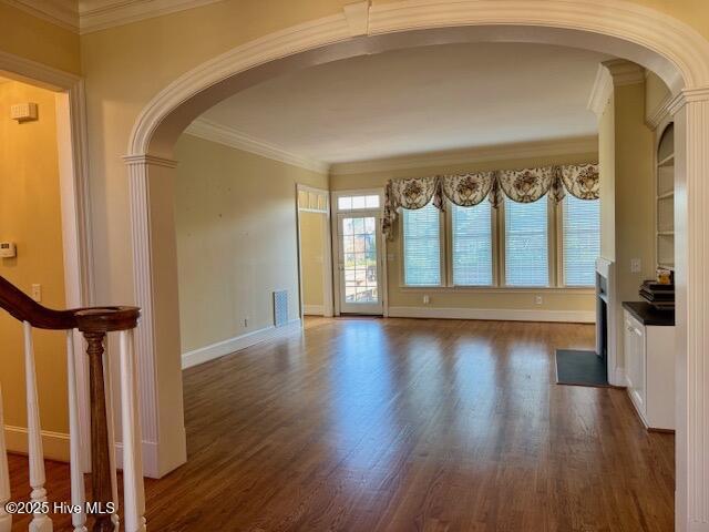 unfurnished living room with ornamental molding and dark hardwood / wood-style flooring