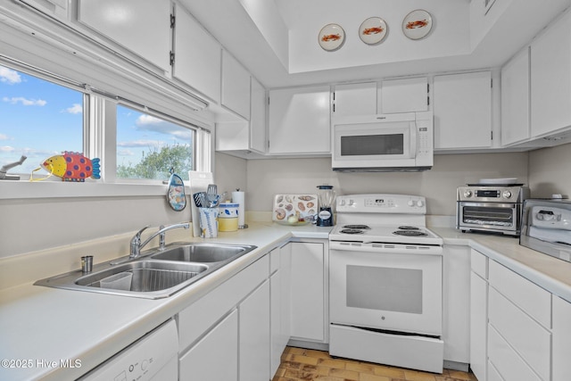 kitchen featuring sink, white appliances, and white cabinets