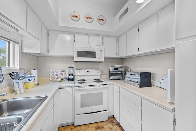 kitchen with sink, white appliances, and white cabinets