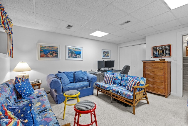 living room featuring light colored carpet and a drop ceiling