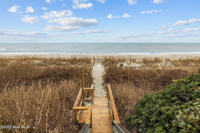 view of community featuring a water view and a beach view