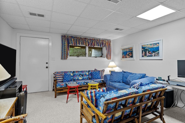 living room featuring carpet flooring and a drop ceiling