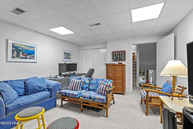 living room featuring a paneled ceiling and carpet floors