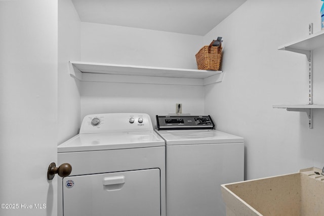 clothes washing area featuring separate washer and dryer and sink