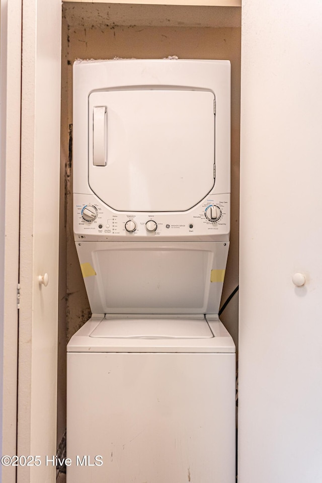 washroom featuring stacked washer and clothes dryer