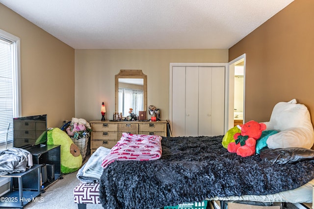 bedroom with carpet, a textured ceiling, and a closet