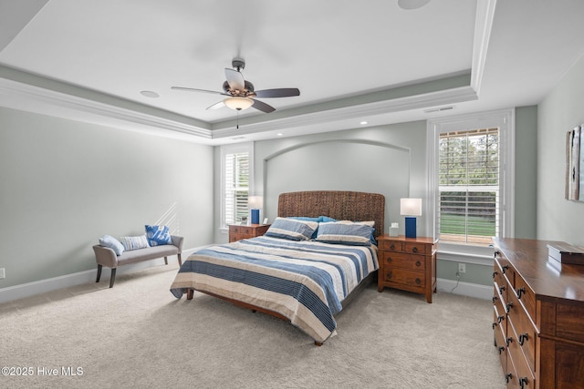 carpeted bedroom featuring multiple windows, a raised ceiling, and ceiling fan