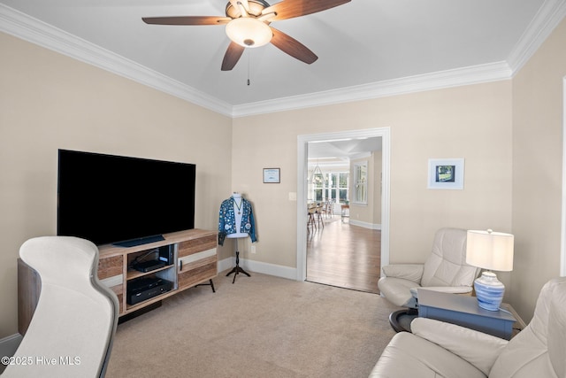 carpeted living room with ornamental molding and ceiling fan