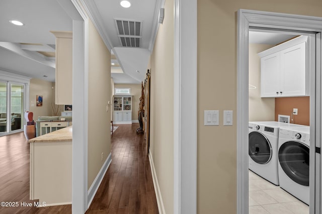 hallway with washer and dryer and light hardwood / wood-style flooring