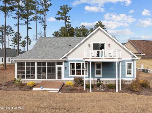 back of house with a balcony, a sunroom, a yard, and central AC unit