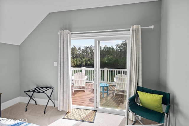 doorway to outside with vaulted ceiling and carpet flooring