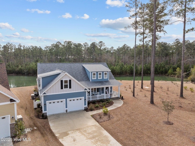 view of front of property featuring a garage, a water view, and a porch