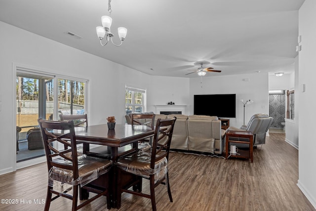 dining space with hardwood / wood-style flooring and ceiling fan with notable chandelier