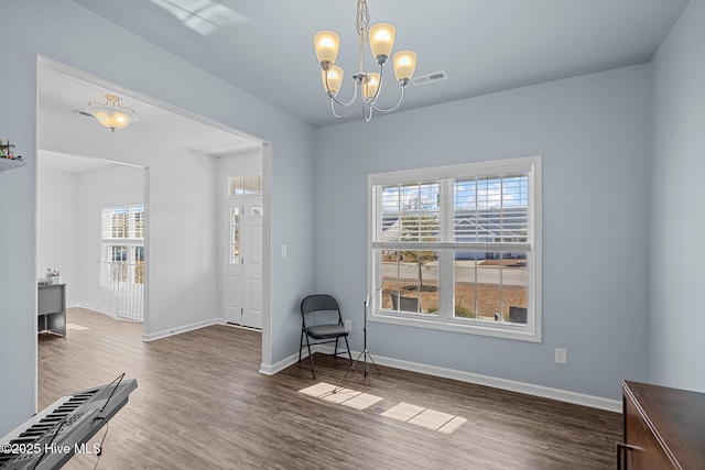 unfurnished room with dark hardwood / wood-style flooring and a notable chandelier