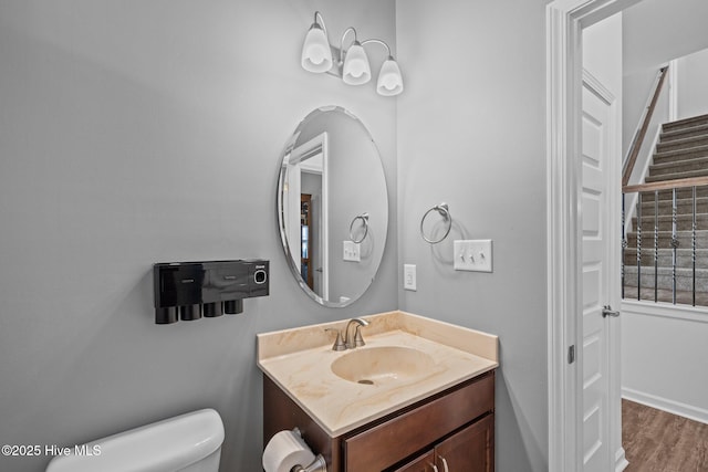 bathroom featuring vanity, hardwood / wood-style floors, and toilet