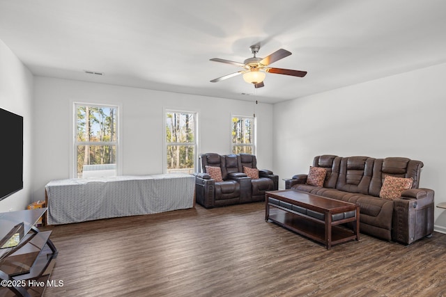 living room with ceiling fan, dark wood-type flooring, and a healthy amount of sunlight