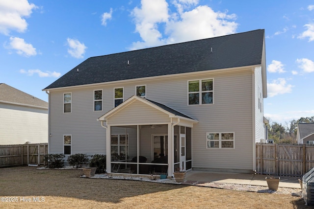 rear view of property featuring a yard, a patio area, and a sunroom