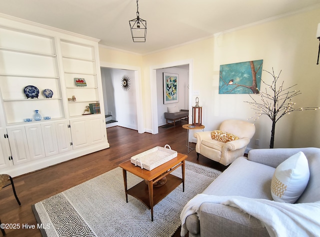 living room with crown molding, dark wood-type flooring, and built in shelves