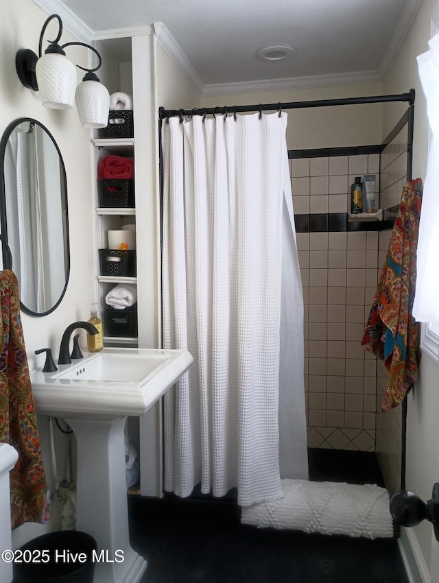 bathroom with ornamental molding, sink, and walk in shower