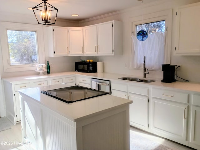 kitchen featuring sink, white cabinetry, dishwasher, a kitchen island, and pendant lighting