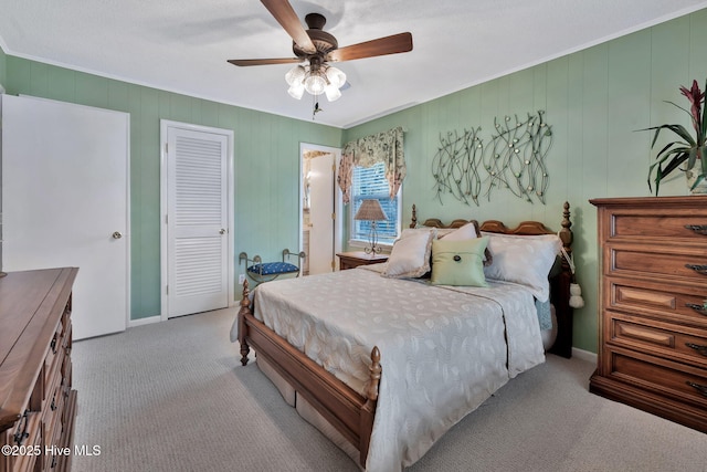 carpeted bedroom featuring crown molding, ceiling fan, and a closet