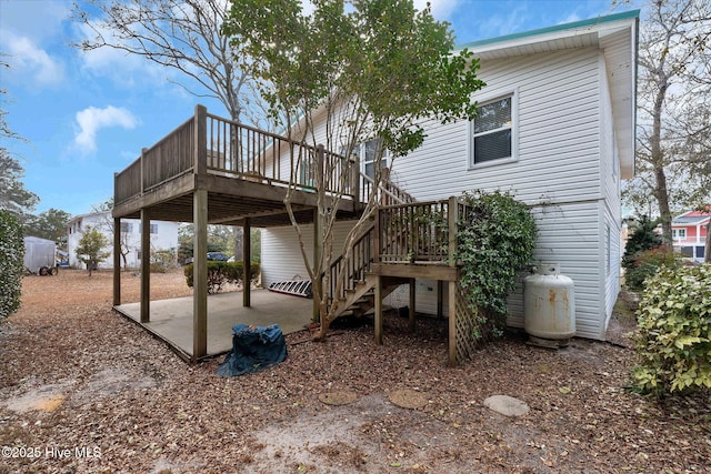 back of property with a wooden deck and a patio