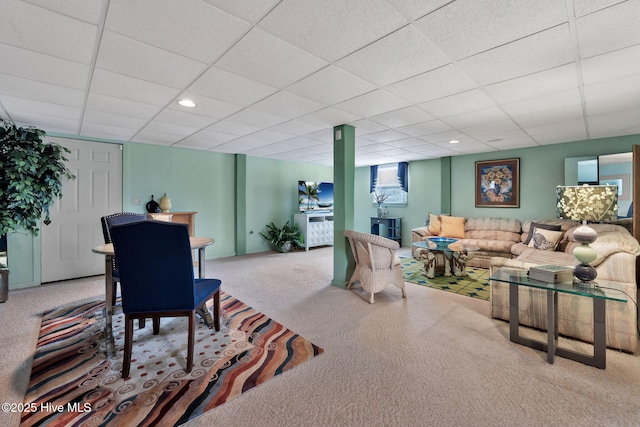 living room featuring carpet and a paneled ceiling