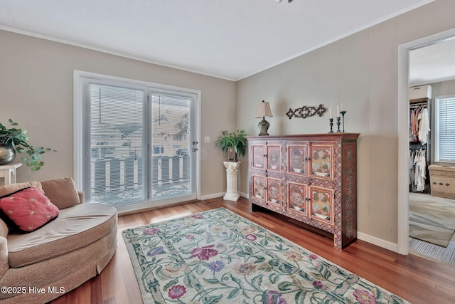 sitting room featuring hardwood / wood-style flooring, ornamental molding, and plenty of natural light