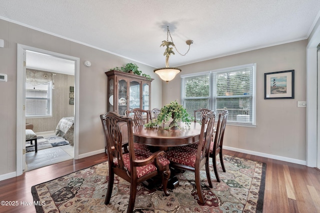 dining area with crown molding, dark wood-type flooring, and a healthy amount of sunlight