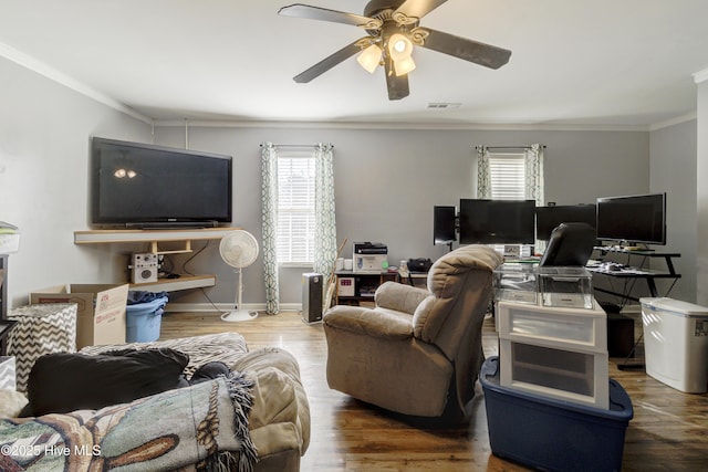 living room with hardwood / wood-style flooring, ceiling fan, and crown molding