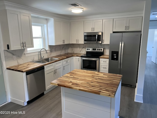 kitchen featuring white cabinets, appliances with stainless steel finishes, sink, and wooden counters