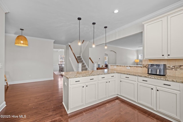 kitchen featuring pendant lighting, white cabinets, and kitchen peninsula