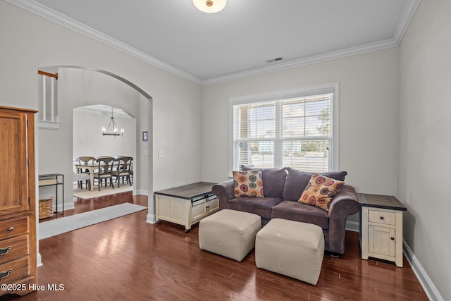 living room featuring dark hardwood / wood-style flooring, a notable chandelier, and ornamental molding