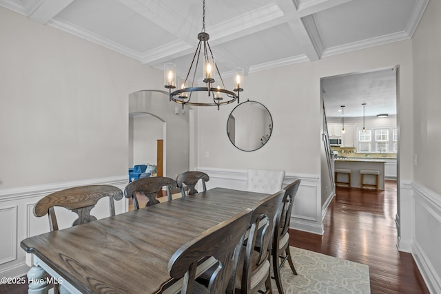 dining room with crown molding, dark wood-type flooring, coffered ceiling, a notable chandelier, and beamed ceiling