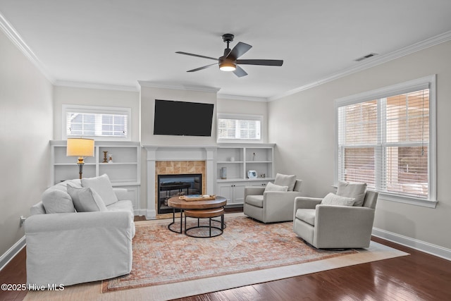 living room with a fireplace, crown molding, wood-type flooring, and plenty of natural light