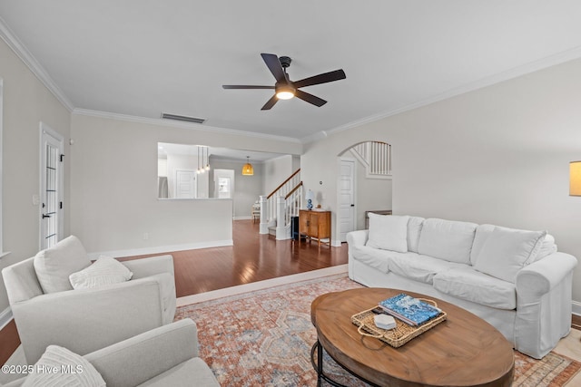 living room featuring hardwood / wood-style flooring, ornamental molding, and ceiling fan